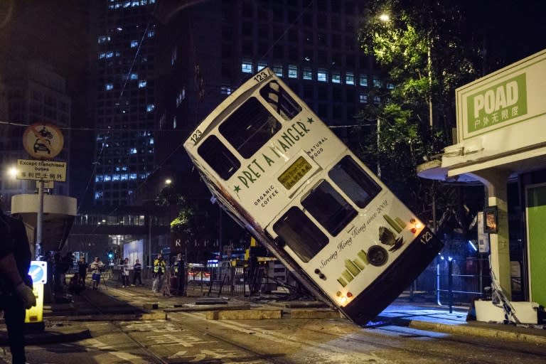 A double-decker Hong Kong tram is lifted by crane after it tipped over on a main road in the city