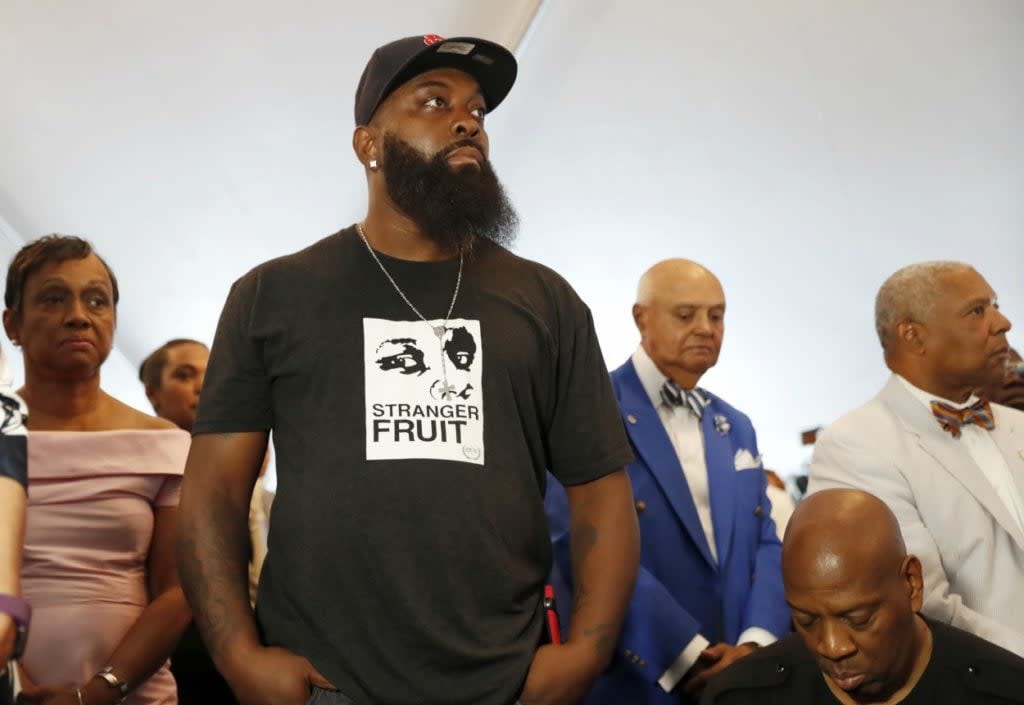 Michael Brown Sr. stands as an honor guard enters during the dedication of a new community empowerment center Wednesday, July 26, 2017, in Ferguson, Mo. (AP Photo/Jeff Roberson)