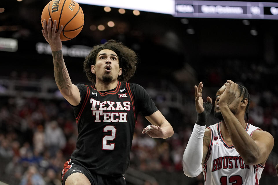 Texas Tech guard Pop Isaacs (2) gets past Houston forward J'Wan Roberts (13) to put up a shot during the first half of an NCAA college basketball game in the semifinal round of the Big 12 Conference tournament, Friday, March 15, 2024, in Kansas City, Mo. (AP Photo/Charlie Riedel)