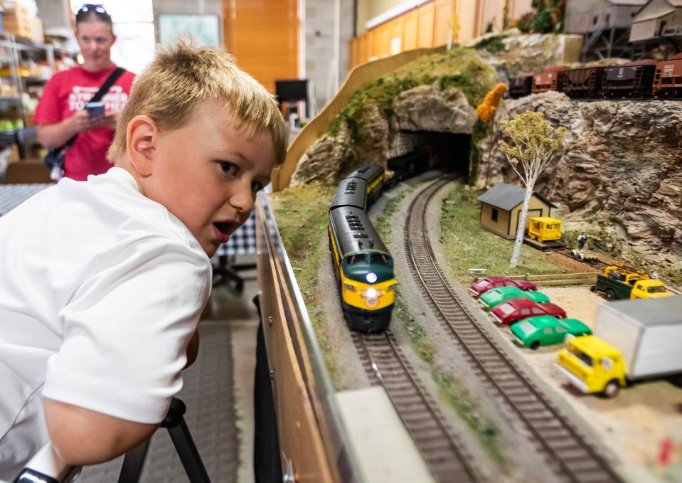 Patrick Richards-Weckop, 6, a member of the Green Bay Area Model Railroaders Club from Hobart, watches a model train move along a track built by the club in the lower level of the Kress Family Branch Library on Aug. 9 in De Pere.