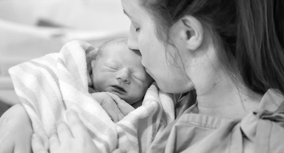 Black and white photo of Jennifer Stenning kissing her newborn son's head.