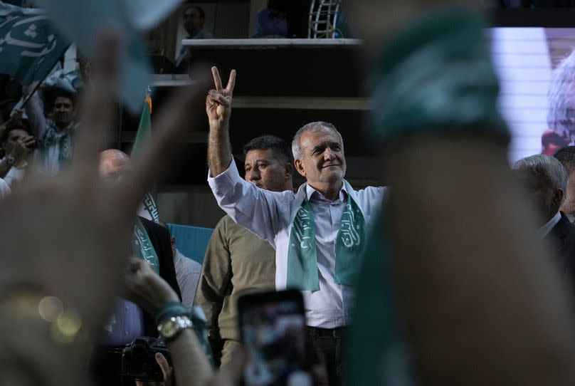 El candidato presidencial iraní Masoud Pezeshkian y sus partidarios hacen el signo de la victoria durante una parada de campaña en Teherán, el 23 de junio de 2024. AP Photo