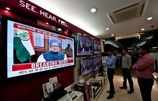 People watch a televised speech by Indian Premier Manmohan Singh in New Delhi. While political opponents accused Singh of selling out the country to foreign interests, the media lauded him for addressing the difficulties facing Asia's third-largest economy
