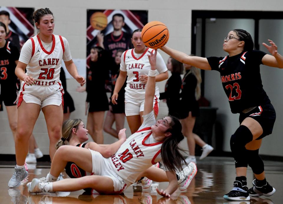 Caney Valley High School's Amaya Toftee (10) fights for control of the ball during basketball action against Morris in Ramona on Dec. 12, 2023. The Lady Trojan fell to Morris, 34-30.