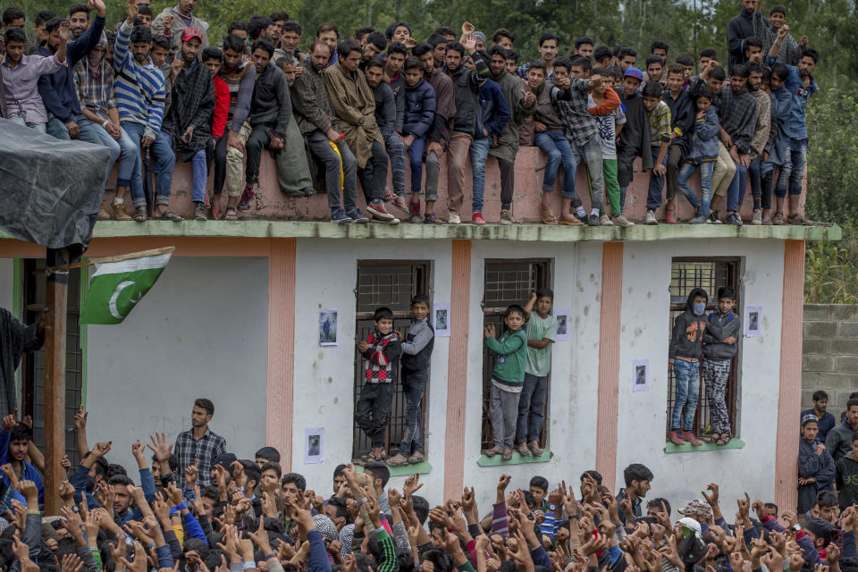 Kashmiri villagerswatch the funeral procession of top rebel commander Gulzar Ahmed Paddroo in Aridgeen, about 75 kilometers south of Srinagar, Indian controlled Kashmir, Saturday, Sept 15, 2018. Indian troops laid a siege around a southern village in Qazigund area overnight on a tip that militants were hiding there, police said. A fierce gunbattle erupted early Saturday, and hours later, five local Kashmiri rebels were killed. (AP Photo/Dar Yasin)