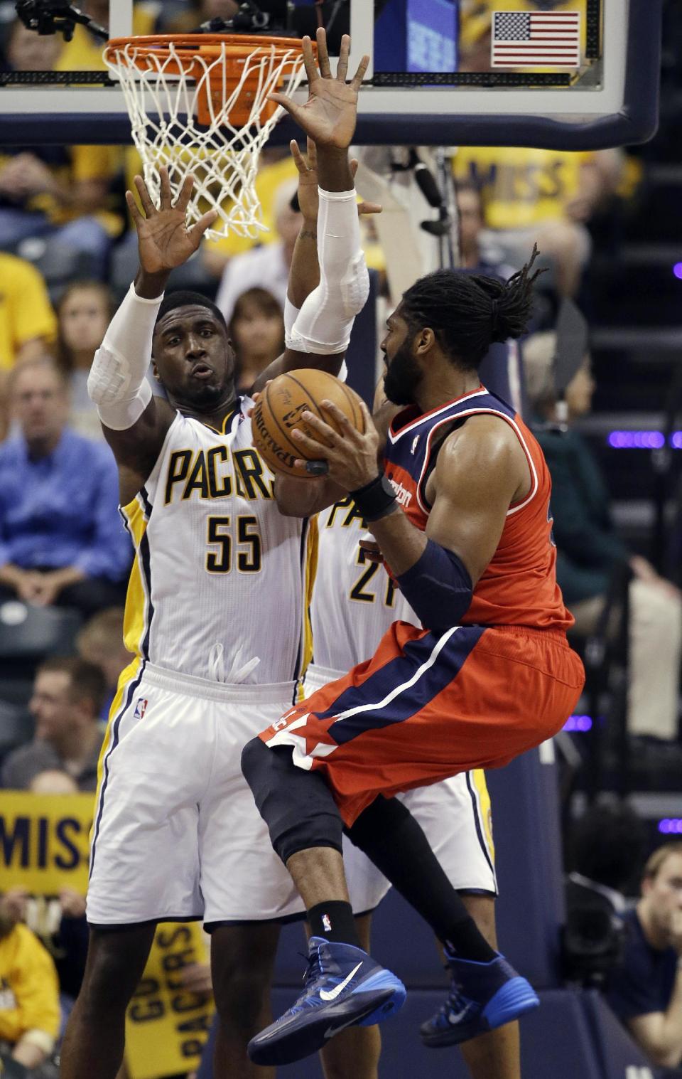 Washington Wizards' Nene Hilario, right, puts up a shot against Indiana Pacers' Roy Hibbert (55) and David West (21) during the second half of game 2 of the Eastern Conference semifinal NBA basketball playoff series Wednesday, May 7, 2014, in Indianapolis. Indiana won 86-82. (AP Photo/Darron Cummings)