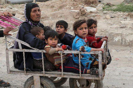 A displaced Iraqi woman and children are transported in a cart as the battle between the Iraqi Counter Terrorism Service and Islamic State militants continues nearby, in western Mosul, Iraq, April 23, 2017. REUTERS/Marko Djurica