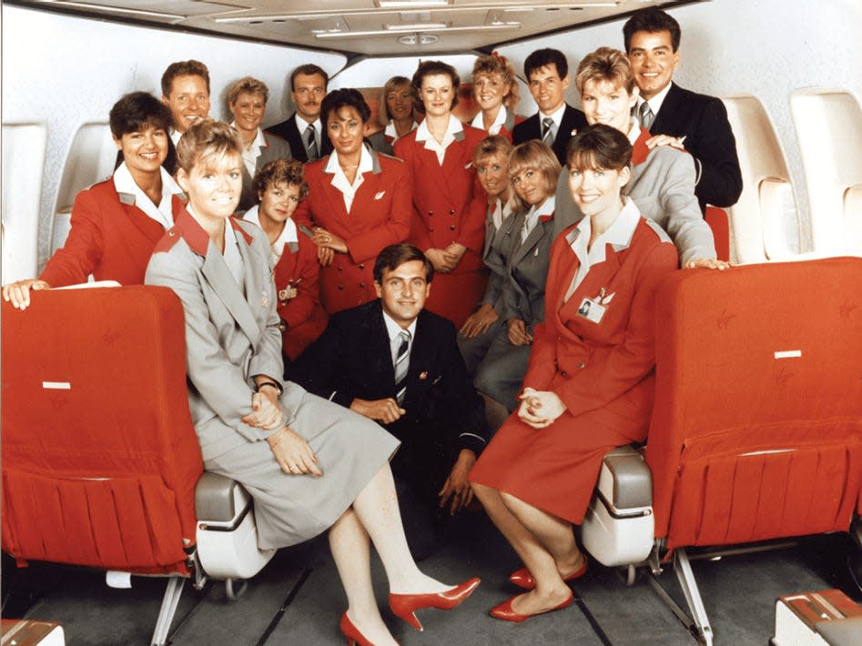 A group of Virgin Atlantic Airways flight attendants from early in the airline's history posing for a photograph in the first-class cabin of a Boeing 747.