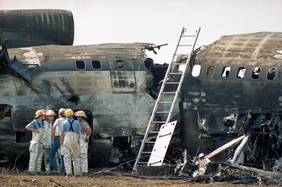 Aug. 31, 1988: Firefighters huddle near the rear of Delta 1141 after extinguishing the blaze. The Boeing 727 crashed during takeoff at Dallas-Fort Worth International Airport.