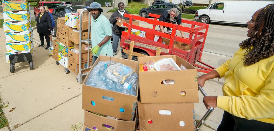 From left to right Nicole Caselius, black jacket, Jimmie Ard, Maurice Allen, president of Street Warriors, middle back, Jim St. Louis, vice president of Street Warriors, and Cynthia Young, director of Spirit of Peace Lutheran Church food pantry, transport food from Allen’s vehicles inside the church Friday, Sept. 23, 2022, located at 5505 W. Lloyd St., Milwaukee.