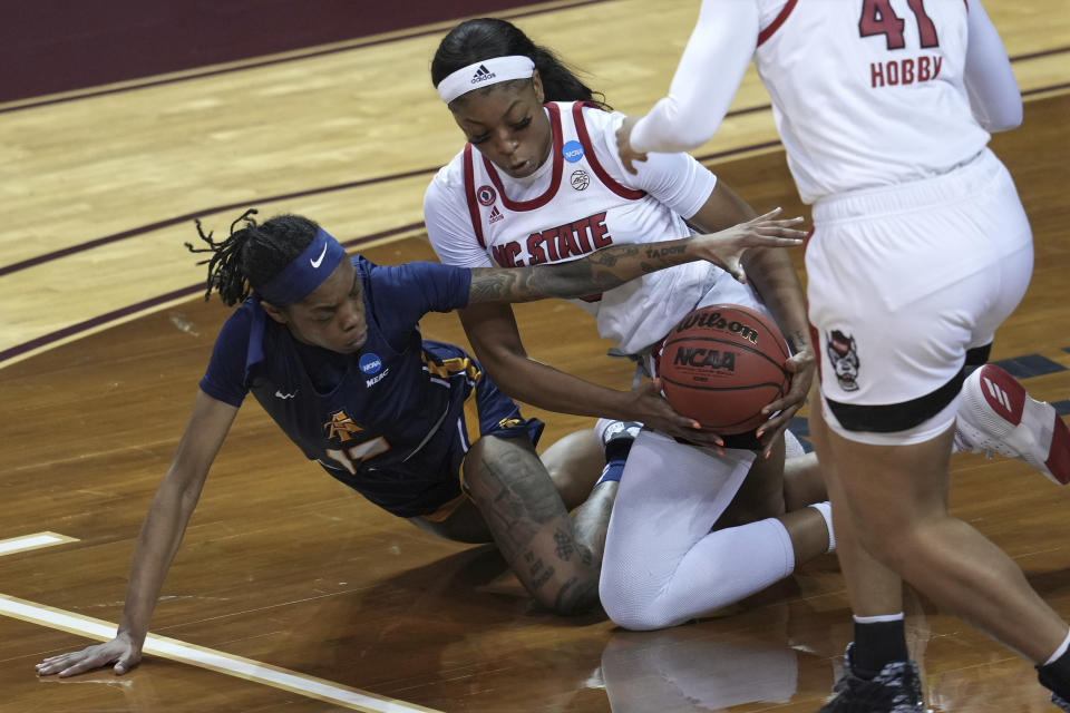 North Carolina A&T's Deja Winters, left, and North Carolina State's Jada Boyd, right, battle for a loose ball during the first half of a college basketball game in the first round of the women's NCAA tournament at the University Events Center in San Marcos, Texas, Sunday, March 21, 2021. (AP Photo/Chuck Burton)