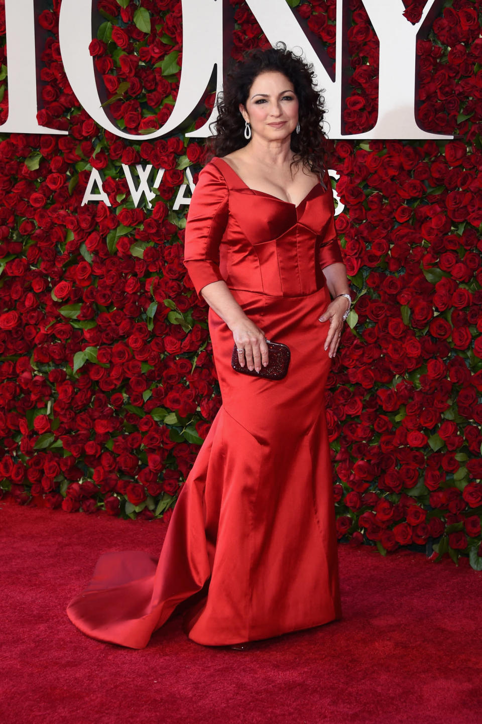 Gloria Estefan wearing a red silk dress 