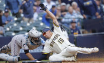 Milwaukee Brewers' Tyrone Taylor (15) scores ahead of the tag by Miami Marlins catcher Jacob Stallings during the fifth inning of a baseball game Thursday, Sept. 14, 2023, in Milwaukee. (AP Photo/Jeffrey Phelps)