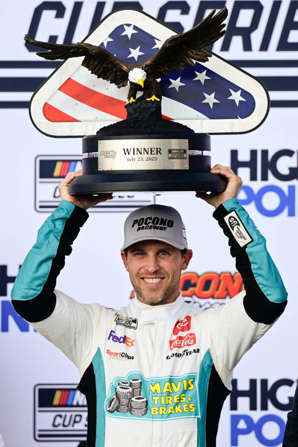 Denny Hamlin poses with the trophy in Victory Lane after winning Sunday’s NASCAR Cup Series auto race at Pocono Raceway. (AP Photo/Derik Hamilton) Derik Hamilton/AP