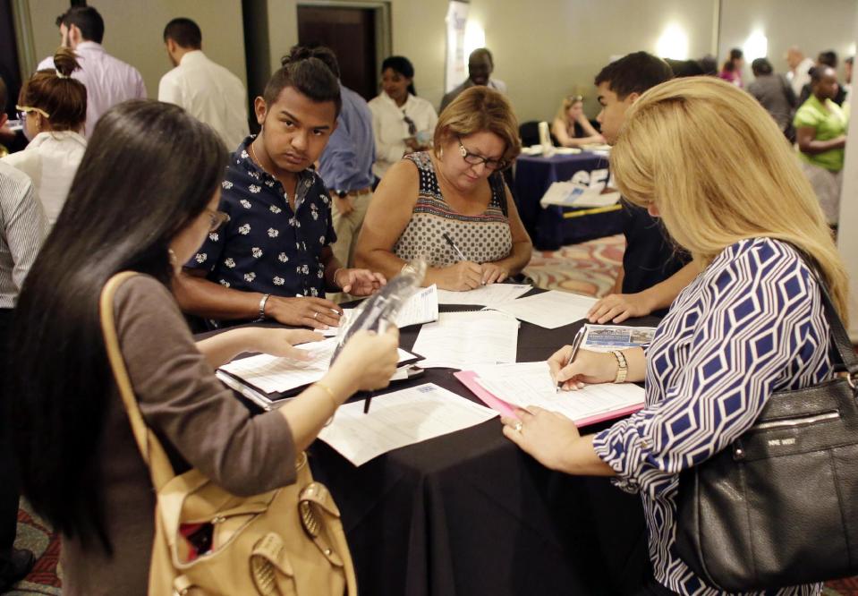 People filling out job applications at a job fair, in Miami Lakes, Fla. (AP Photo/Lynne Sladky, File)