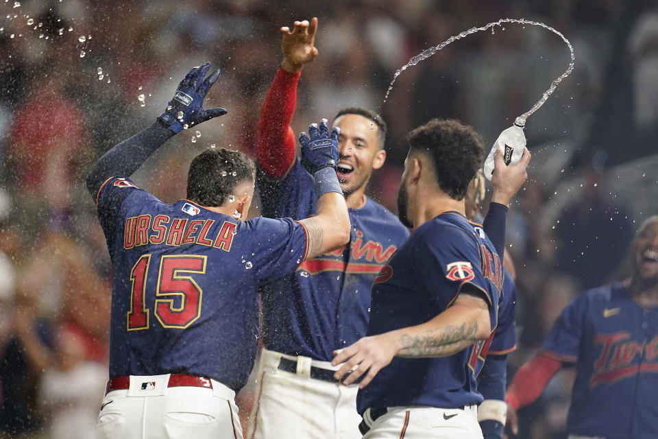 Minnesota Twins' Gio Urshela (15) celebrates with teammates after hitting a walkoff two-run home run during the bottom of 10th inning of a baseball game against the Detroit Tigers in Minneapolis, Monday, Aug. 1, 2022. (AP Photo/Abbie Parr)