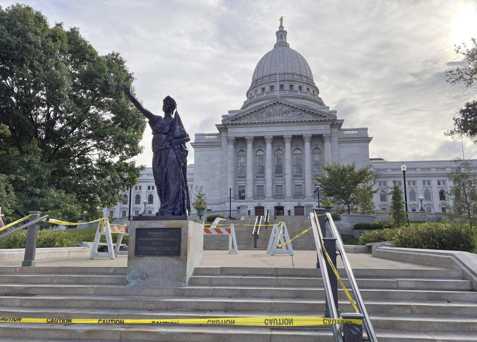 Workers reinstalled a statue Tuesday, Sept. 21, 2021 symbolizing Wisconsin's "Forward" motto outside the state Capitol in Madison, Wis. Protesters tore the 7-foot statue down during a demonstration in June 2020 over George Floyd's death in Minneapolis. (AP Photo/Todd Richmond)