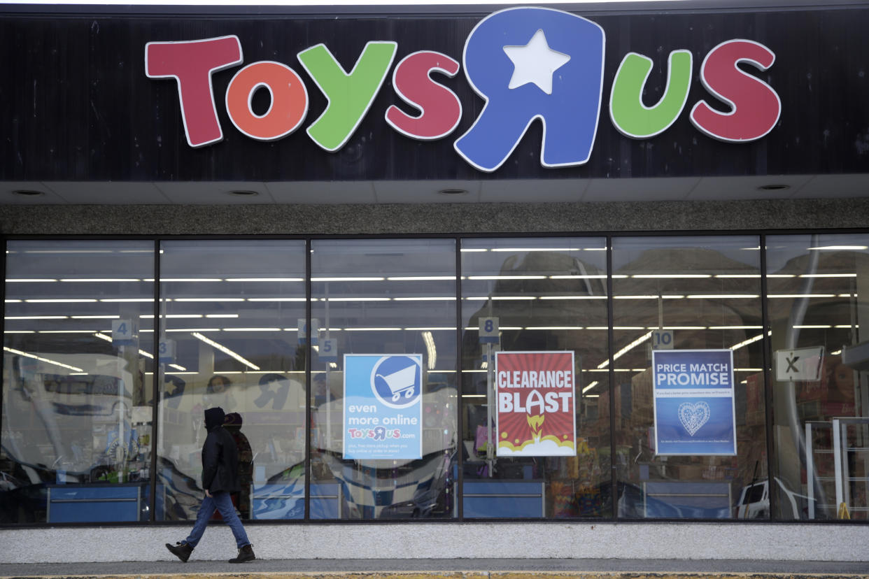 FILE - In this Jan. 24, 2018, file photo, a person walks near the entrance to a Toys R Us store, in Wayne, N.J. A group of investors is planning a potential comeback for Geoffrey the giraffe and his crew. Investors that control the assets of the company say they now see a better chance of a return on investment by potentially reviving the toy chain, rather than selling it off for parts. (AP Photo/Julio Cortez, File)