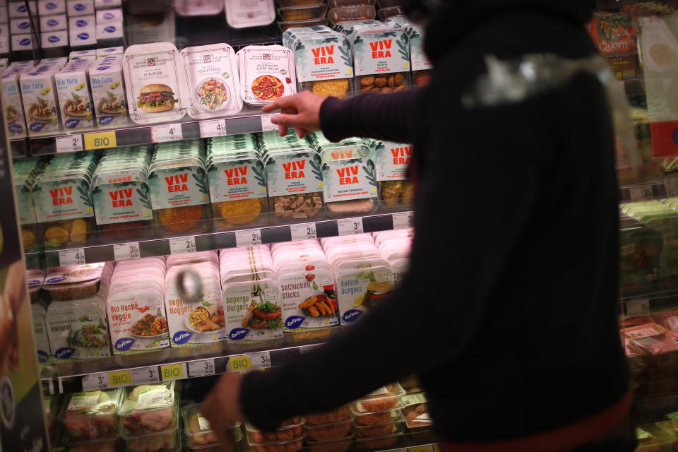 A store clerk shows plant based products at a supermarket chain in Brussels, Friday, Oct. 23, 2020. European lawmakers rejected Friday proposals that could have prevented plant-based products without meat from being labeled sausages or burgers. Following the votes on agricultural products at the European Parliament, the so-called veggie burgers, soy steaks and vegan sausages can continue to be sold as such in restaurants and shops across the union. (AP Photo/Francisco Seco)