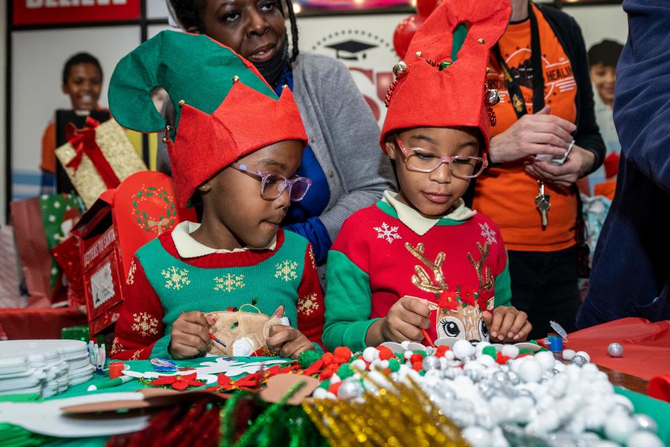 Janiyah Johnson and Jalayah Johnson male crafts at the "Angel Tree" holiday party at Center City Mall in Paterson on Friday, Dec. 16, 2022.