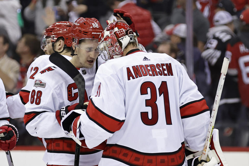 Carolina Hurricanes center Martin Necas (88) congratulates Frederik Andersen after the Hurricanes defeated the New Jersey Devils in Game 4 of an NHL hockey Stanley Cup second-round playoff series Tuesday, May 9, 2023, in Newark, N.J. The Hurricanes won 6-1. (AP Photo/Adam Hunger)