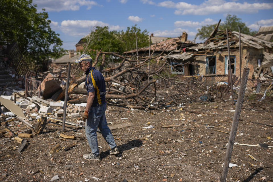 A local resident stands next to a house destroyed in a Russian bombing in Bakhmut, eastern Ukraine, Tuesday, May 24, 2022. The town of Bakhmut has been coming under increasing artillery strikes, particularly over the last week, as Russian forces try to press forward to encircle the city of Sieverodonetsk to the northeast. (AP Photo/Francisco Seco)