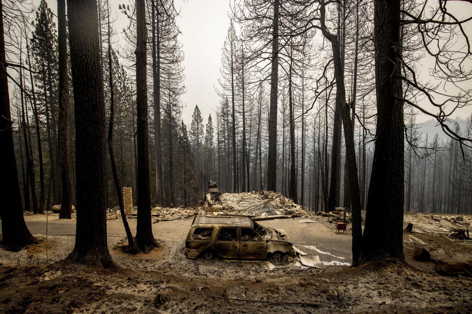 A car burned by the Caldor Fire rests in the driveway of a property on Tyler Drive in Grizzly Flats, Calif., on Wednesday, Aug. 18, 2021. (AP Photo/Ethan Swope)