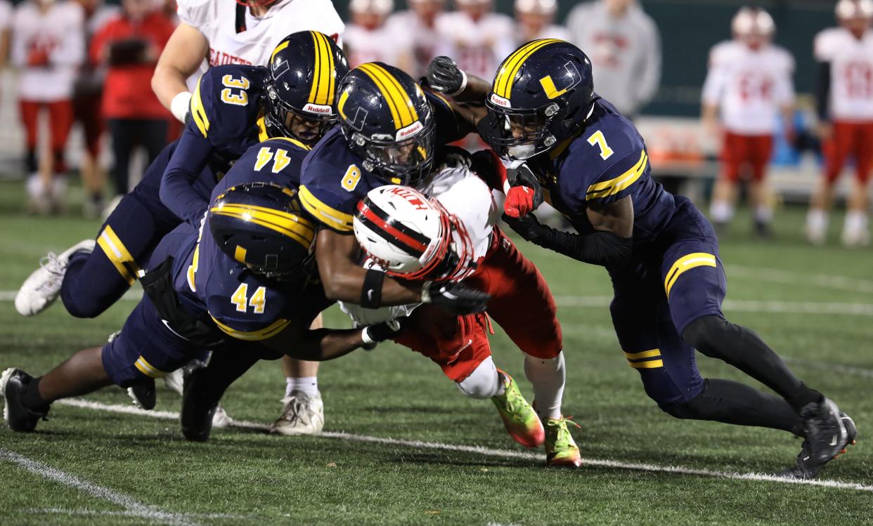 Hilton's Robert Lowry gets tackled by UPrep's Isaiah Moonschein, Taivon Wilson and Jaylyn Melton with teammate Landon Nesmith coming up from behind.