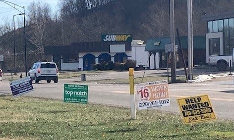 Numerous "Now Hiring" and "Help Wanted" signs are posted along Southgate Parkway in Cambridge as local employers seek employees from a dwindling workforce in Guernsey County.