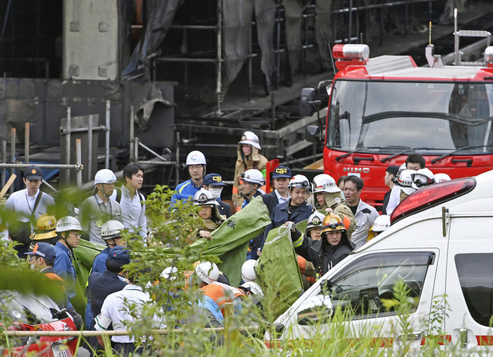 Rescuers work at the site of a fire in Tama city, Tokyo's western suburbs, Thursday, July 26, 2018. The fire broke out Thursday afternoon, causing casualties and injuring a number of people at the building being constructed. (Kyodo News via AP)