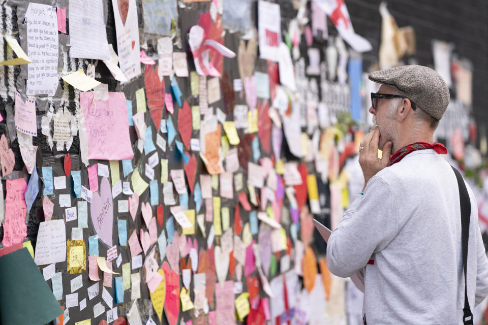 A man looks at the messages of support left on a mural of Manchester United striker and England player Marcus Rashford, on the wall of the Coffee House Cafe on Copson Street, in Withington, Manchester, England, Tuesday July 13, 2021. The mural was defaced with graffiti in the wake of England losing the Euro 2020 soccer championship final match to Italy. (AP Photo/Jon Super)