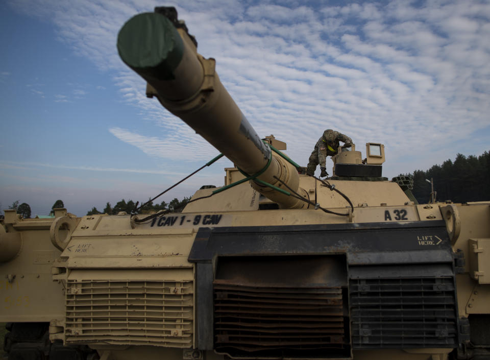 FILE - In this Oct. 21, 2019, file photo a member of the US Army's 1st Armored Battalion of the 9th Regiment, 1st Division from Fort Hood in Texas prepare to unload Abrams battle tanks from rail cars as they arrive at the Pabrade railway station some 50 km (31 miles) north of the capital Vilnius, Lithuania. The Army has begun hiring more agents and support staff for its criminal investigations, as the new civilian director works to correct widespread failures that surfaced last year after a string of murders and other crimes at Fort Hood, Texas. (AP Photo/Mindaugas Kulbis, File)