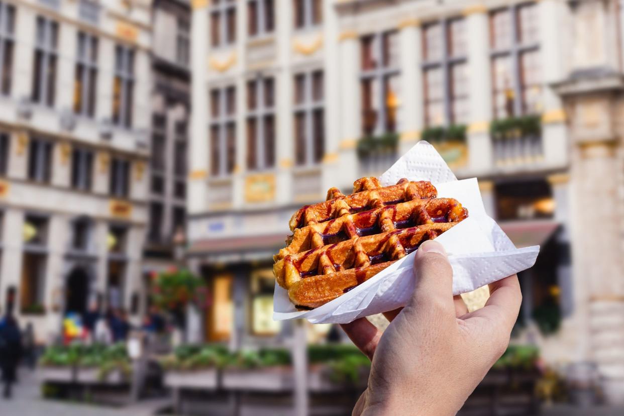 Male Hand Holding a Waffle With Chocolate Drizzle in Brussels, Belgium