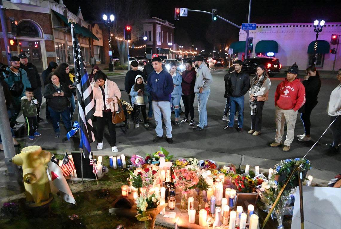 A crowd gathers at memorial on the corner of Mill and Second Streets where the community gathered for a vigil honoring slain Selma officer Gonzalo Carrasco Jr. Thursday, Feb 2, 2023 in Selma.