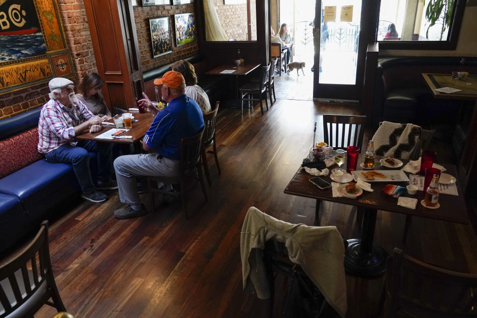 Customers eat dinner in the dining room of San Pedro Brewing Company on Friday, May 29, 2020, in the San Pedro area of Los Angeles. Restaurants were allowed to open their dining rooms with restrictions today. (AP Photo/Ashley Landis)