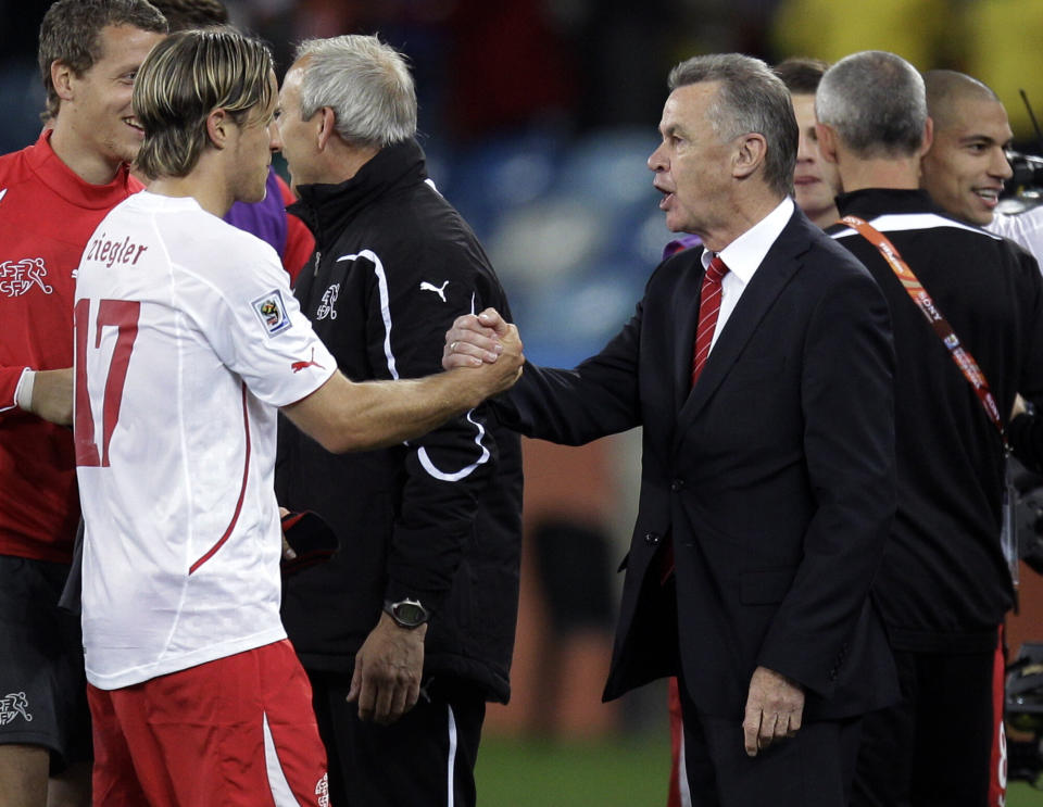 Switzerland head coach Ottmar Hitzfeld, right, greets Switzerland's Reto Ziegler following the World Cup group H soccer match between Spain and Switzerland at the stadium in Durban, South Africa, Wednesday, June 16, 2010.  (AP Photo/Daniel Ochoa de Olza)