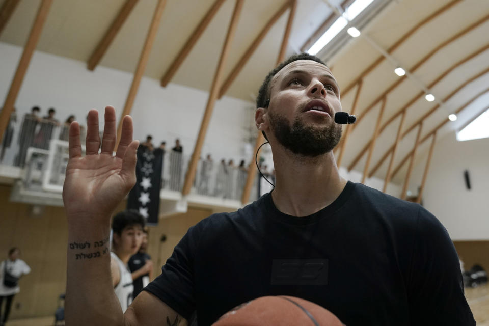 File - In this June 23, 2019, file photo, Golden State Warriors' Stephen Curry waves toward the fans while coaching at a high school basketball camp in Tokyo. Someday, years or even decades from now, at one of those celebratory reunions teams like to do, Stephen Curry knows he and Kevin Durant will reminisce with fondness about their three insanely successful years together on the Golden State Warriors. For now, Curry is embracing "new beginnings" as the oldest player on a Golden State roster that will look far different come training camp next month. (AP Photo/Jae C. Hong, File)