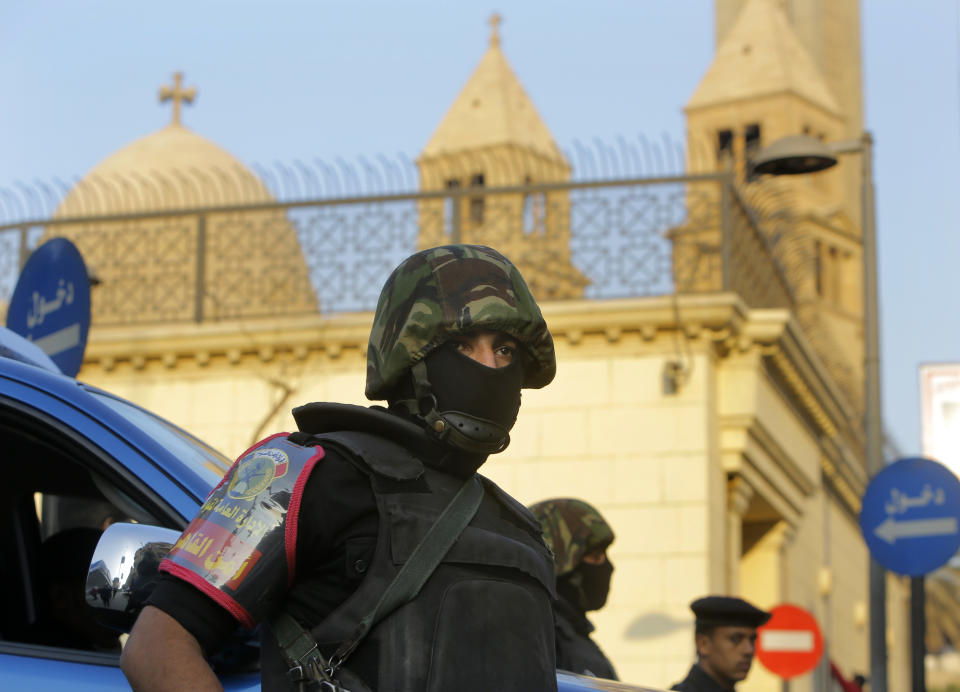 A masked Egyptian policeman stands guard in front of St. Mark Cathedral in Cairo, Egypt, Monday, Jan. 6, 2014 ahead of Coptic Christmas eve mass. Egyptian authorities put up a heavy security cordon around the Coptic cathedral in Cairo hours before Christmas Eve mass, using bomb-sniffing dogs, metal detectors and officers.(AP Photo/Amr Nabil)