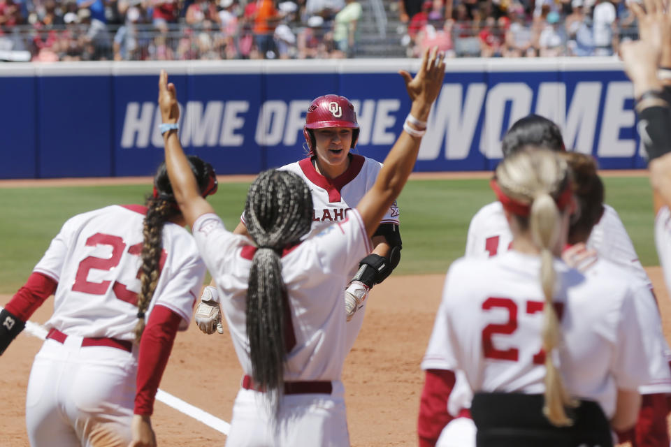 Oklahoma's Kinzie Hansen, center top, runs to home plate after hitting a two-run home run against Tennessee during the third inning of an NCAA softball Women's College World Series game Saturday, June 3, 2023, in Oklahoma City. (AP Photo/Nate Billings)