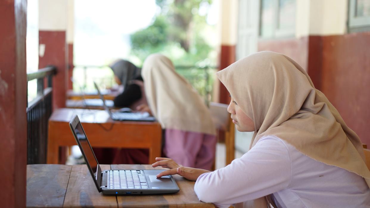  Indonesian junior high school students study online using chromebook laptops. 