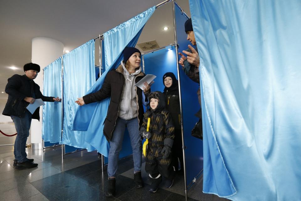 FILE - Voters talk to each other while leaving voting booths at a polling station in Astana, Kazakhstan, Sunday, Nov. 20, 2022. A snap presidential election in late November delivered a second term to President Tokayev, with official election figures saying he netted over 81% of the vote. Final results showed that over 77% of voters supported the changes, which included stripping Nazarbayev of his remaining state posts and veto powers over important areas of domestic and foreign policy. (AP Photo/Stanislav Filippov, File)