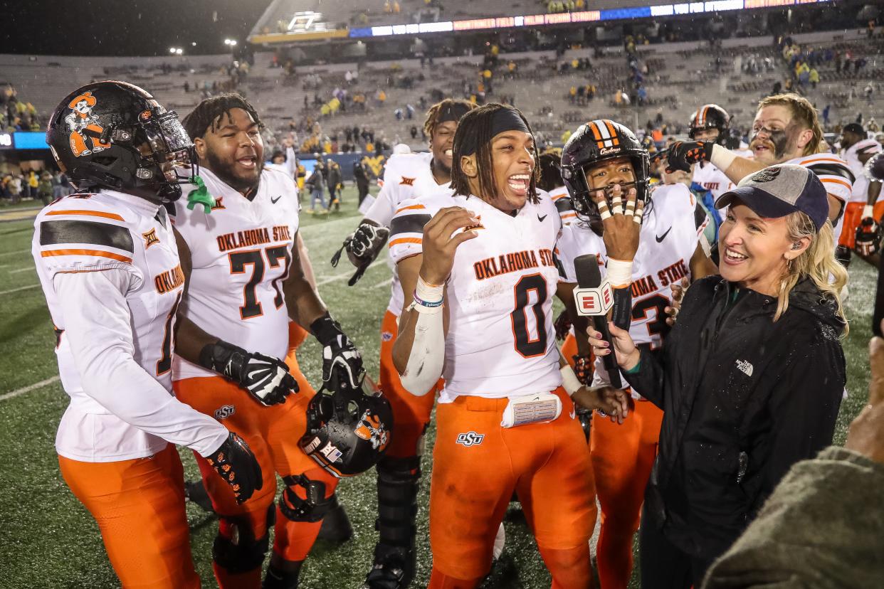 Oct 21, 2023; Morgantown, West Virginia, USA; Oklahoma State Cowboys players celebrate during a TV interview with Oklahoma State Cowboys running back Ollie Gordon II (0) after defeating the West Virginia Mountaineers at Mountaineer Field at Milan Puskar Stadium. Mandatory Credit: Ben Queen-USA TODAY Sports