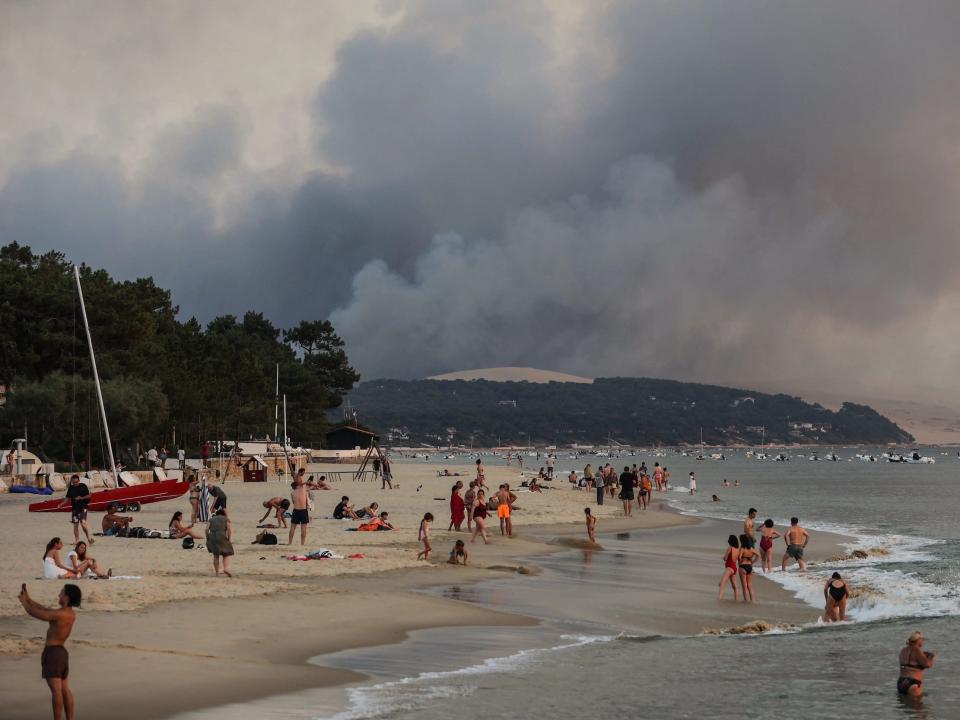 Smoke rises in the backdrop of beachgoers in France