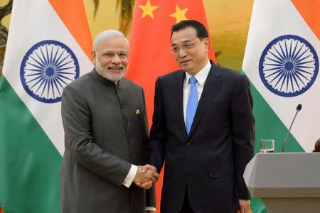 Indian Prime Minister Narendra Modi (L) shakes hands with Chinese Premier Li Keqiang during a news conference at the Great Hall of the People in Beijing, China, May 15, 2015. REUTERS/Kenzaburo Fukuhara/Pool