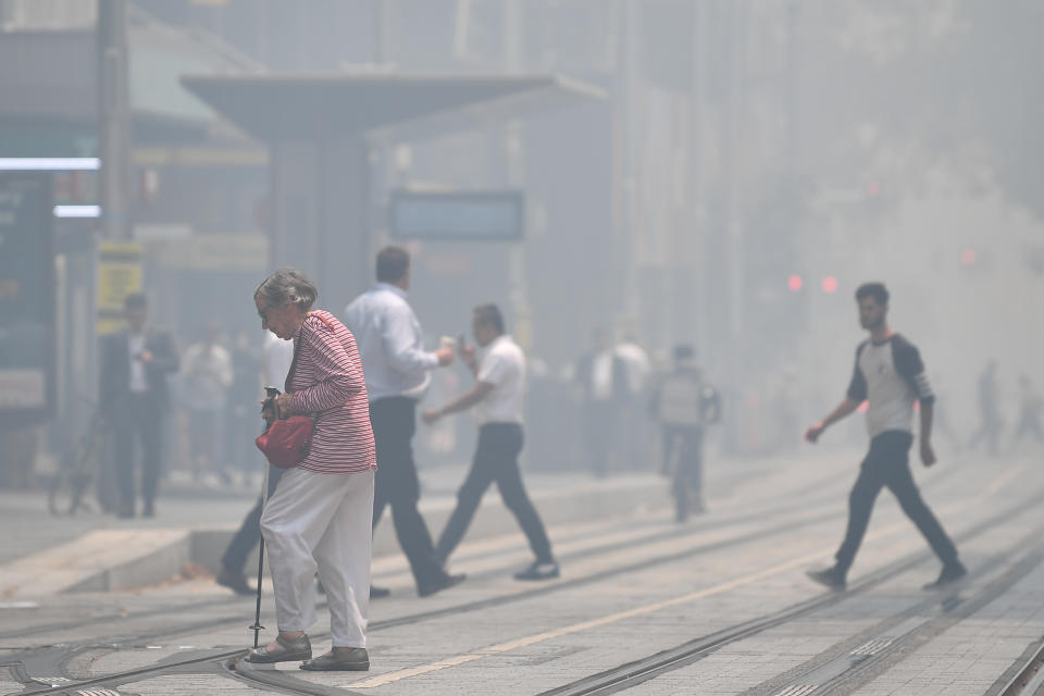 Pedestrians cross George Street as smoke haze blankets the city. Source: AAP