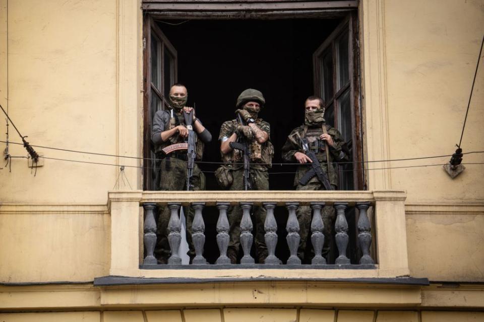 Wagner Group mercenaries stand on the balcony of a building in Russia's Rostov, on June 24, 2023. The mercenary group's founder, Yevgeny Prigozhin, claimed on June 24 that his forces control all military sites in the city. (Roman Romokhov/AFP via Getty Images)