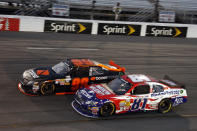 Travis Pastrana (99) passes Jason Bowles (81) during the NASCAR Nationwide Series auto race at Richmond International Raceway, Friday, April 27, 2012, in Richmond, Va. (AP Photo/LAT, Lesley Ann Miller)