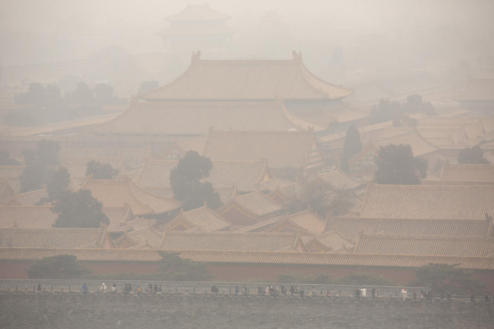 Tourists walk along the wall of the Forbidden City on a day with high levels of air pollution in Beijing, Saturday, Jan. 18, 2020. Although Chinese state media recently reported that Beijing's levels of PM2.5 air pollutants in 2019 had fallen in comparison to previous years, air quality indices soared to levels considered hazardous in China's capital on Saturday. (AP Photo/Mark Schiefelbein)