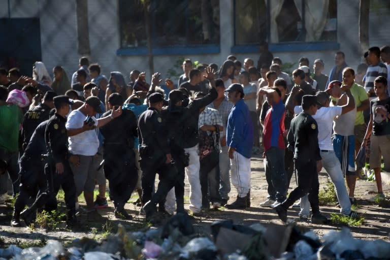 Guatemalan anti-riot policem guard a group of inmates after regaining the control of Canada maximum security prison in Escuintla department, 75 km south of Guatemala City on November 30, 2015