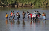 Un grupo de migrantes centroamericanos cruza el río fronterizo Suchiate desde el lado de México a Guatemala, cerca de Tecún Umán, Guatemala, el martes 21 de enero de 2020. (AP Foto/Moises Castillo)